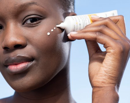 Women with black skin using AKN Mat SPF30 sun protection for acne-prone skin
